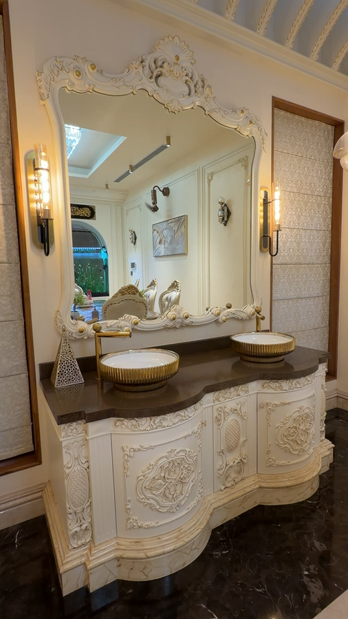 Video of an ornate double vanity with a decorative mirror and gold-toned fittings